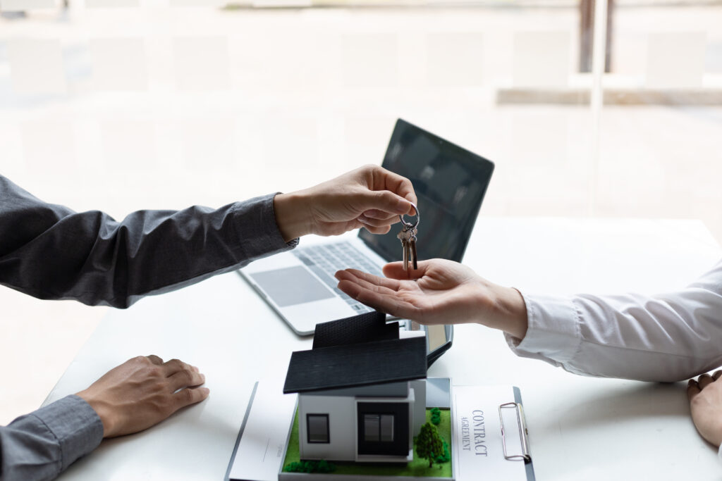 Home buyer partnered with an RMP Law Real Estate Lawyer in Arkansas to ensure a legally sound home buying experience. The real estate agent is handing the keys over to the homebuyer. 