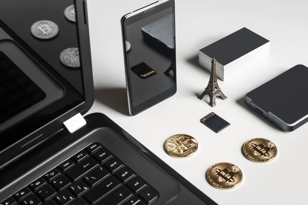 A picture of a laptop, cell phone, external storage, SD card, and cryptocurrency to represent digital assets as part of the estate plan. 