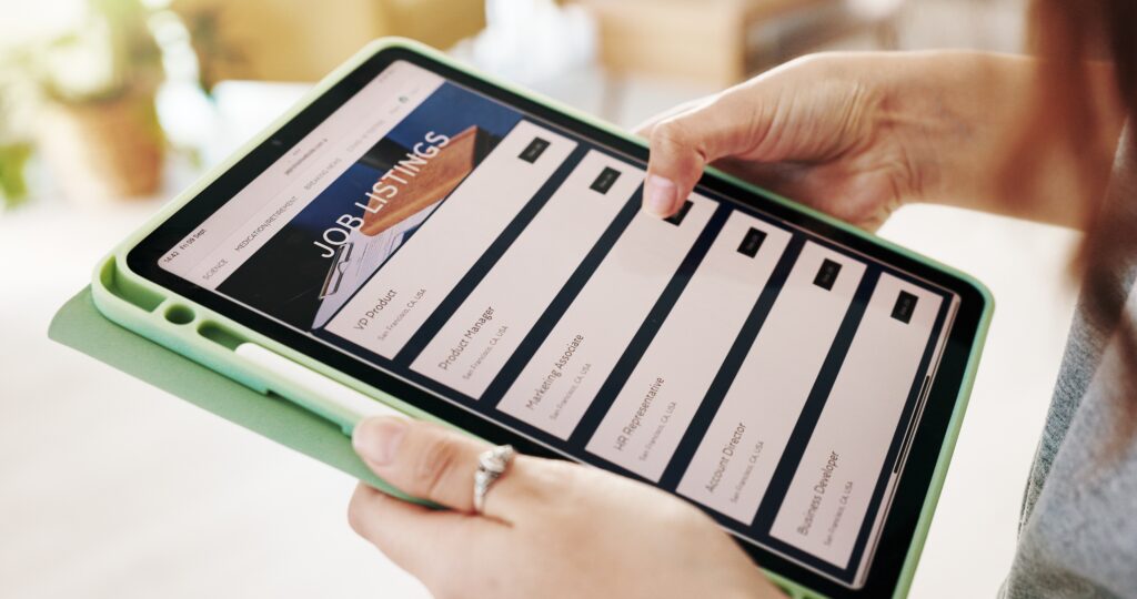 Woman looking through job listings comparing salaries with businesses who have pay transparency. 
