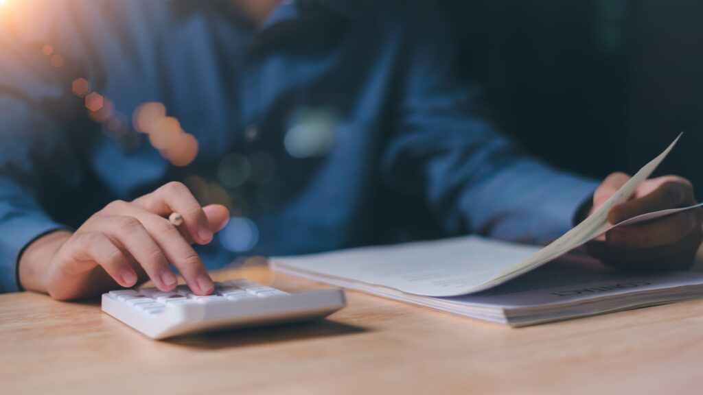 Tax professional wearing blue long sleeved shirt typing on a calculation assessing 2026 standard tax dedications. 