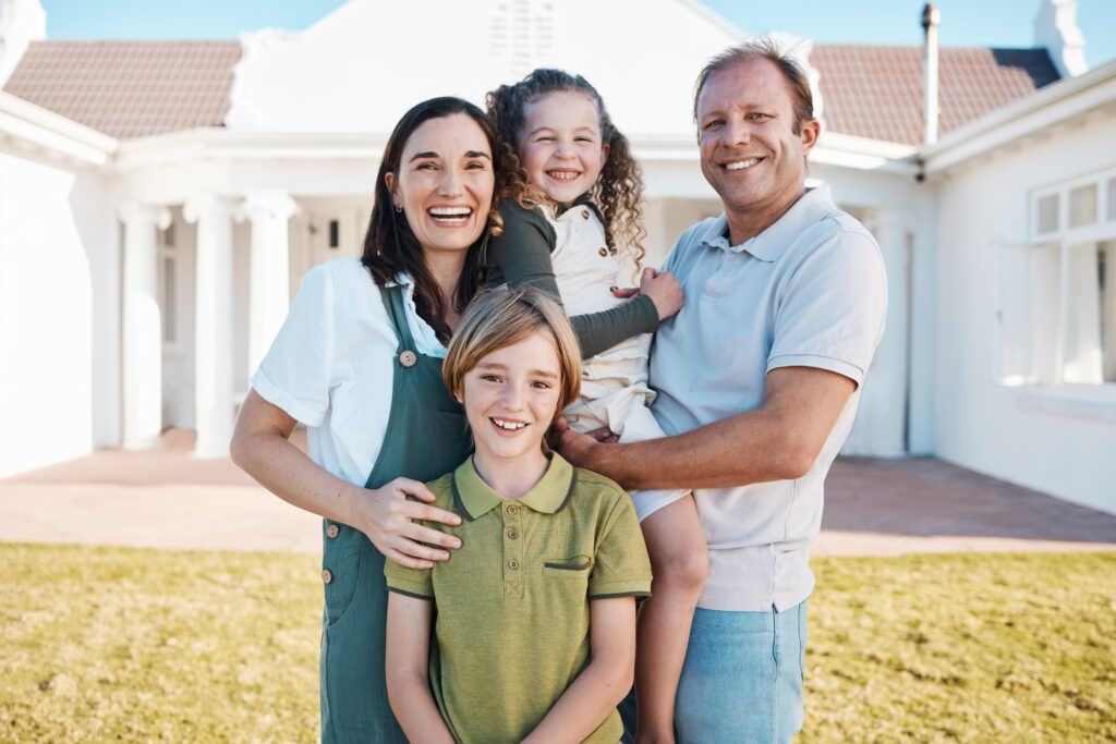 happy Arkansas family of four standing outside their house after updating their estate plan with their Arkansas estate attorney.