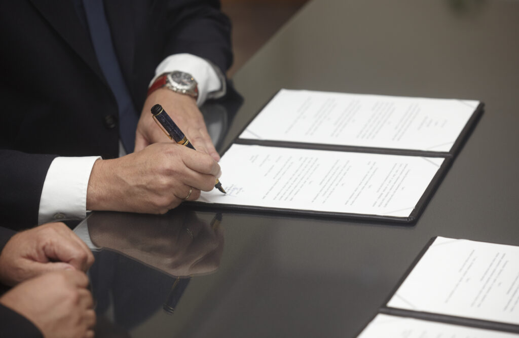 Operating agreement being signed between two business owners to determine what happens to an Arkansas LLC when an owner dies.